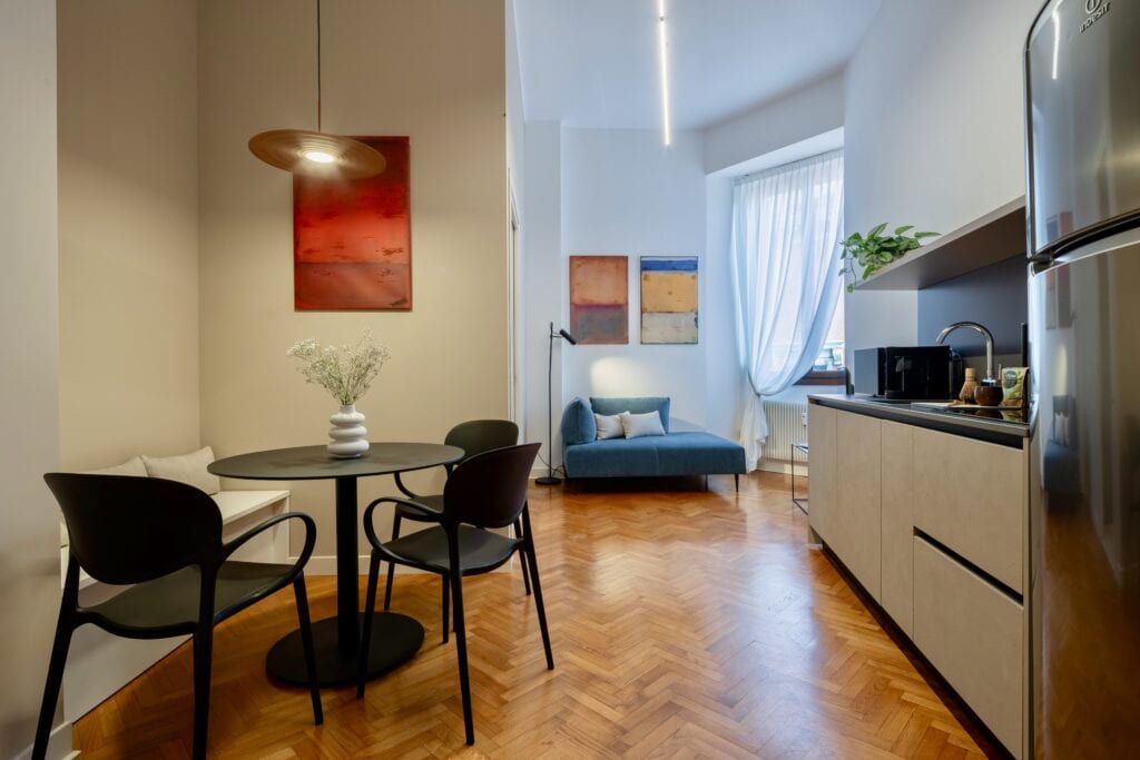 Modern open-space kitchen with a cozy lounge area, bright and elegantly designed.